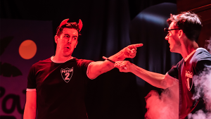 two actors on stage, one holding a magic wand